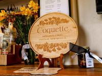 Coquette logo wooden sign on bar at Read Street tasting room